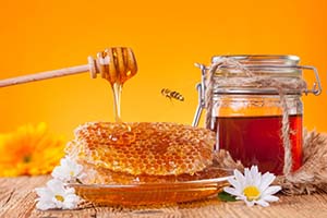 Honig mit Honigwabe und Glas angerichtet