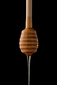 Fließender Honig vor schwarzem Hintergrund